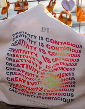 Load image into Gallery viewer, "Creativity is contagious" art quote on a tote bag in a thermal effect