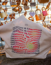 Load image into Gallery viewer, &quot;Creativity is contagious&quot; art quote on a tote bag in a thermal wavy text art effect
