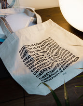 Load image into Gallery viewer, Canvas tote bag with a wavy distorted text effect graphic
